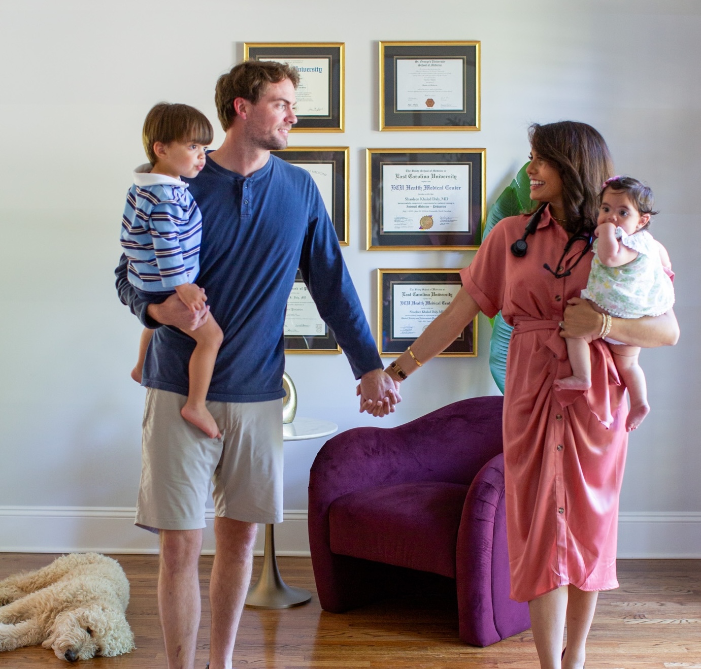 Dr. Daly and her husband standing together while holding their two children