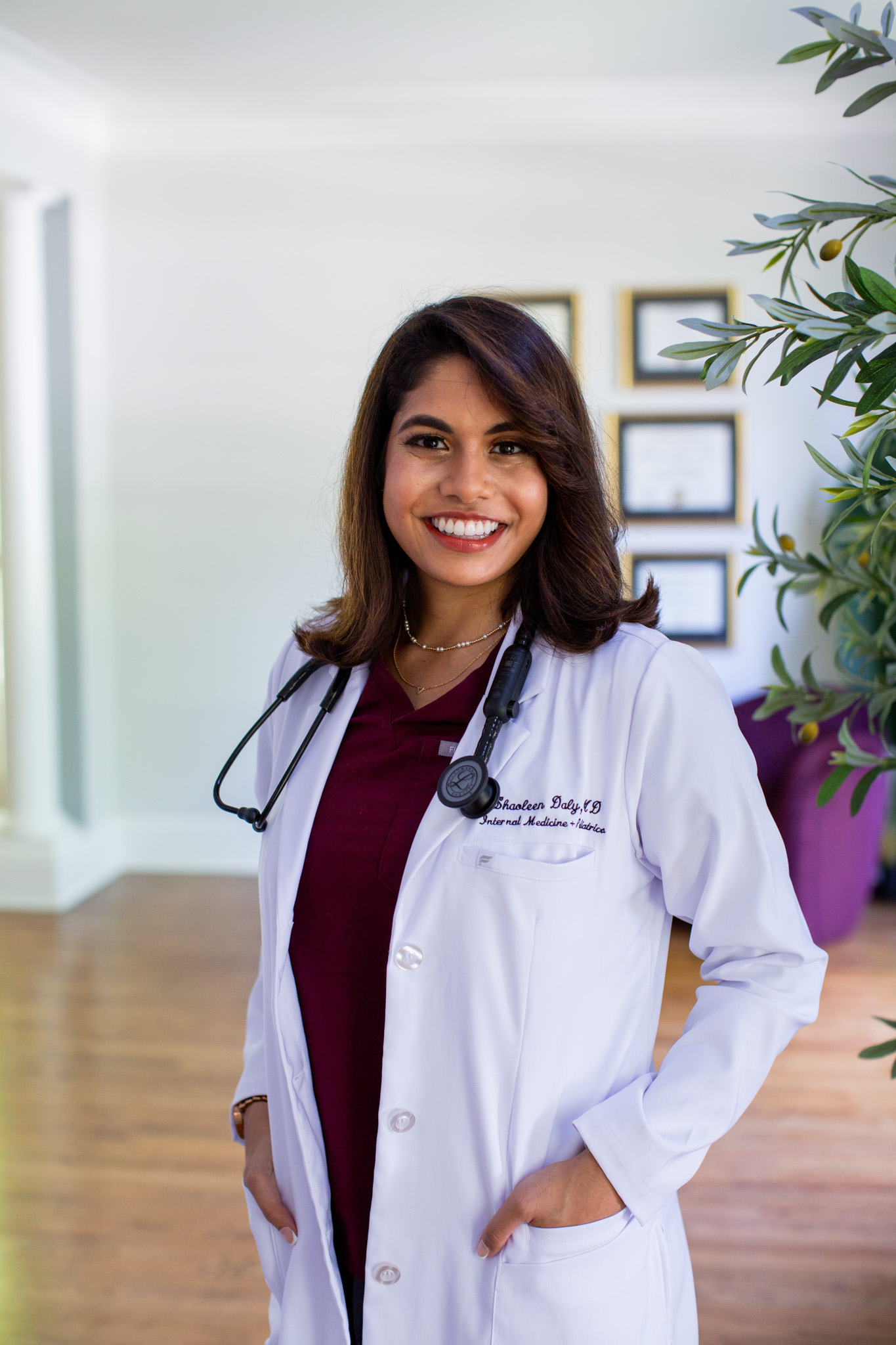 Dr. Shaoleen Daly smiling in her white coat at the Jhuma Medicine office