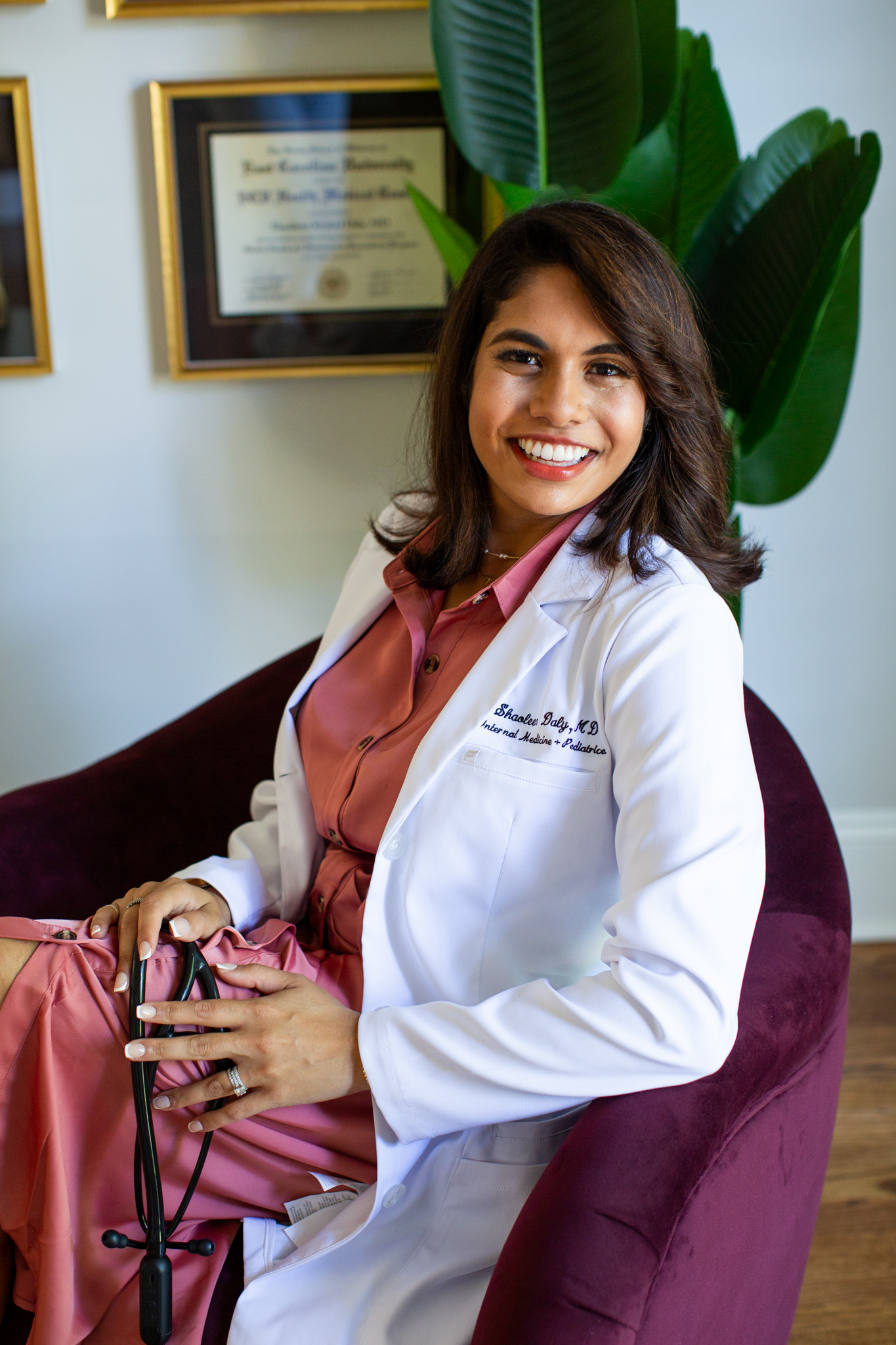 Dr. Shaoleen Daly seated in her office wearing her white coat and holding her stethoscope
