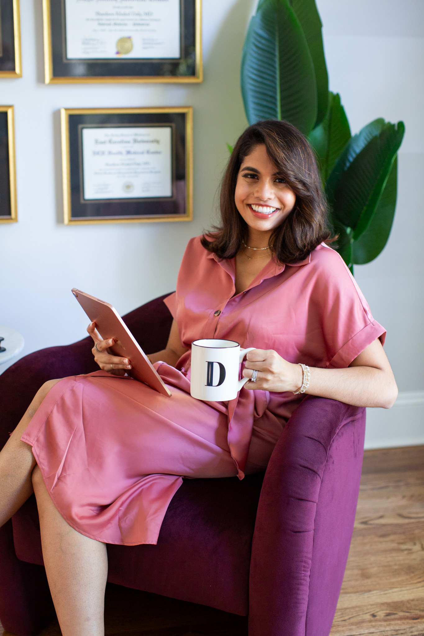 Dr. Shaoleen Daly seated in her office with a tablet and mug