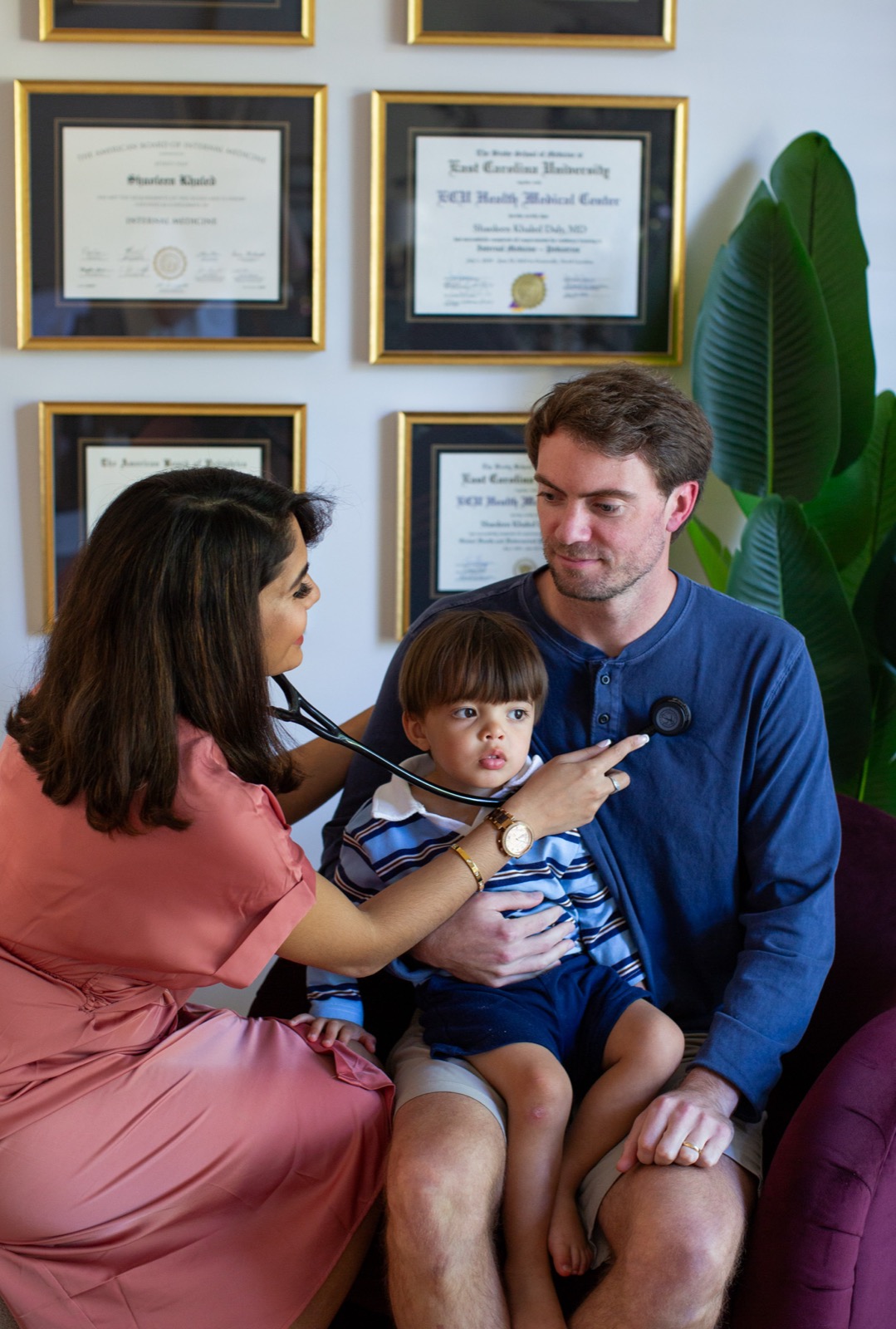Dr. Daly listening while examining a child with his father